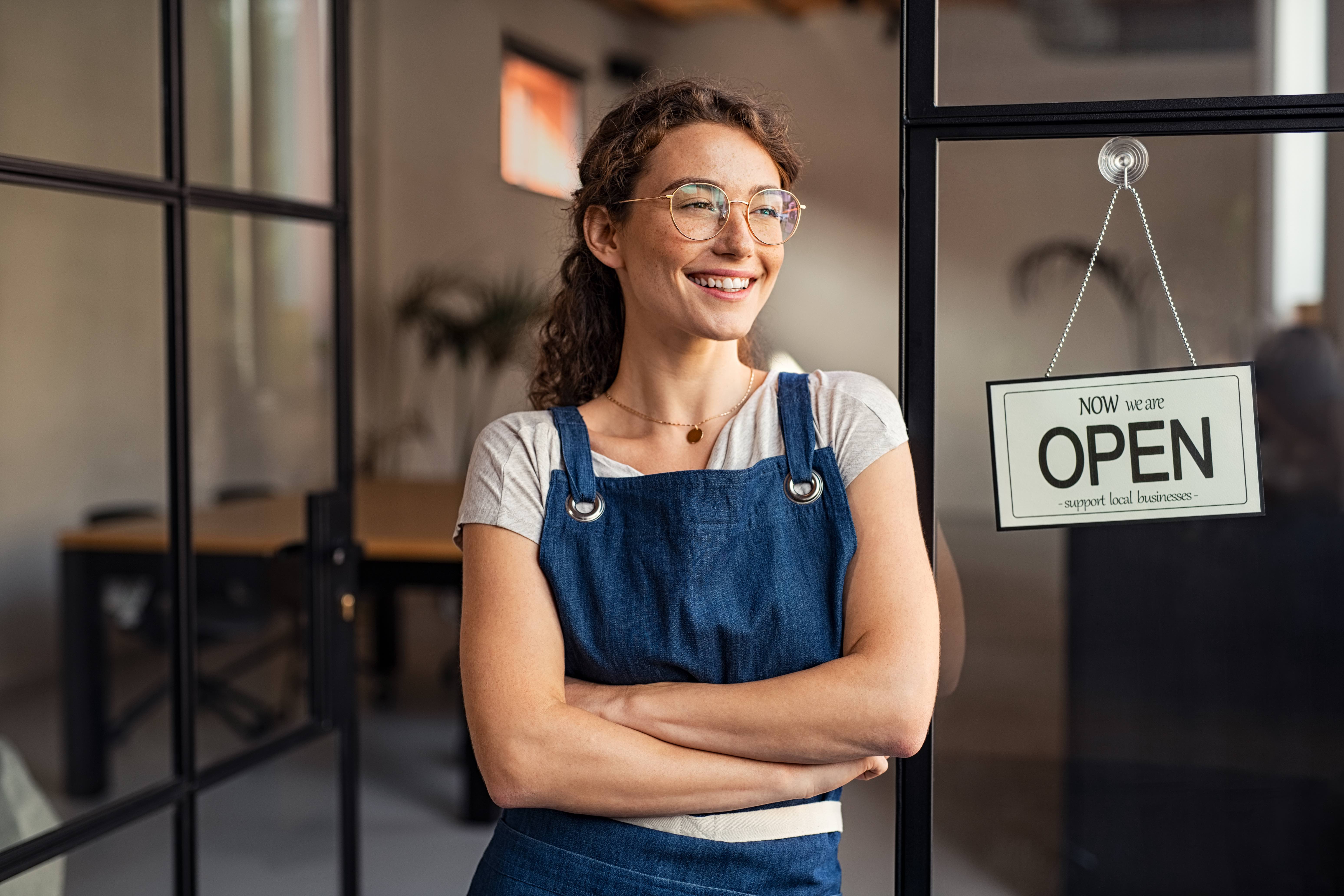 Local laundry delviery business woman ini front of open sign.jpg