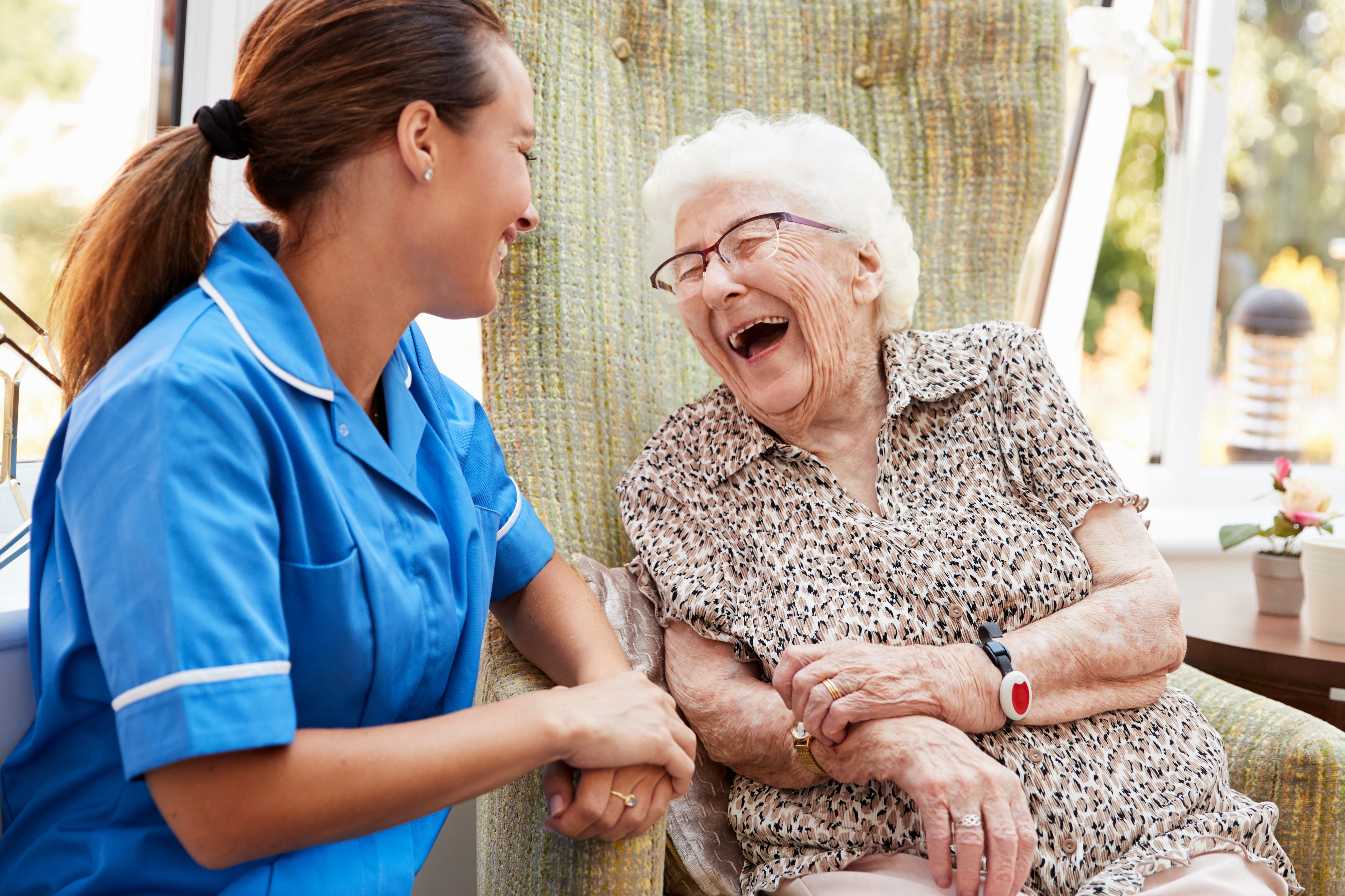 Senior woman laughing with yonger woman laundry delivery.jpg