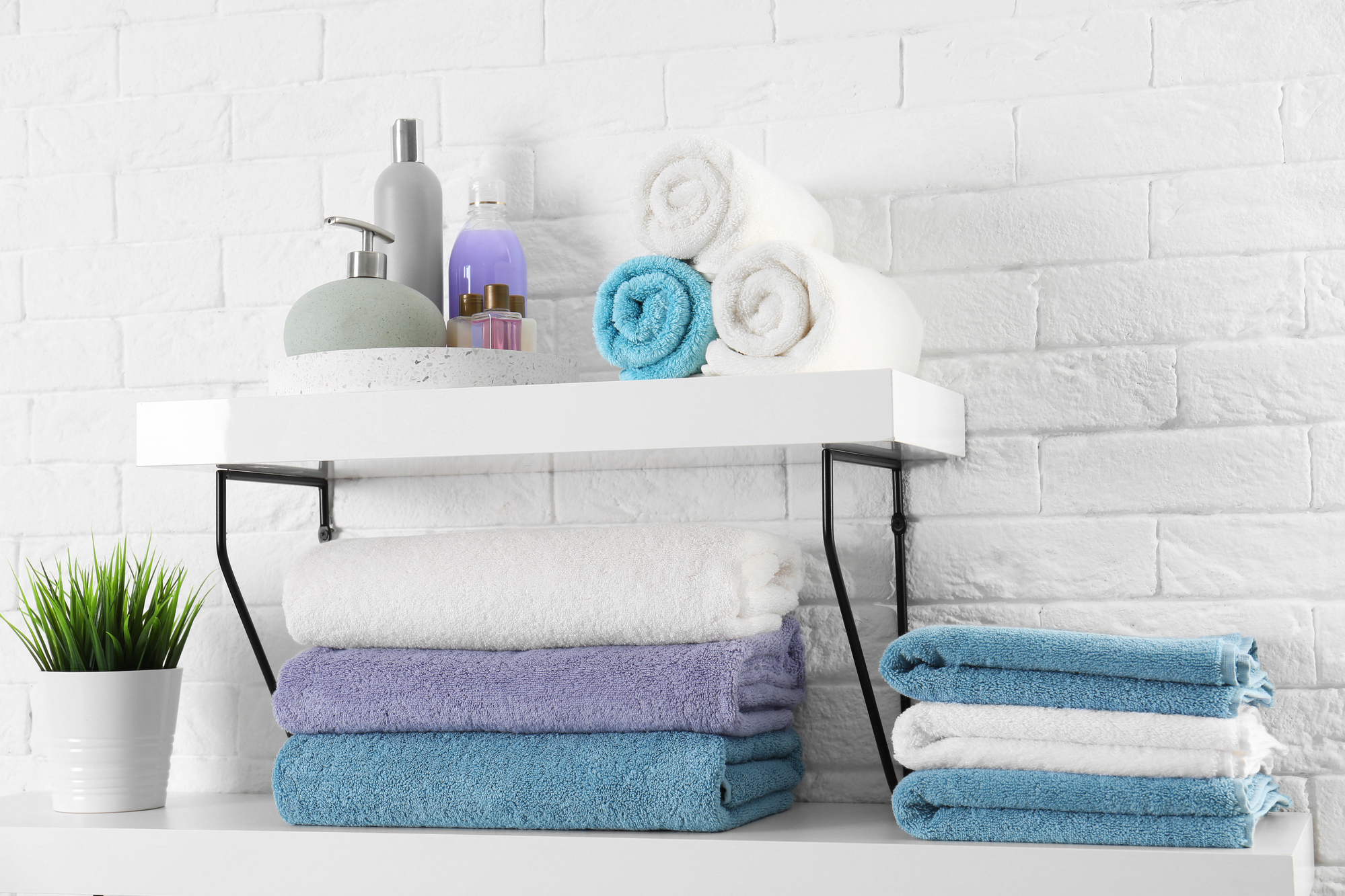 Shelves with clean towels and toiletries on brick wall.jpg