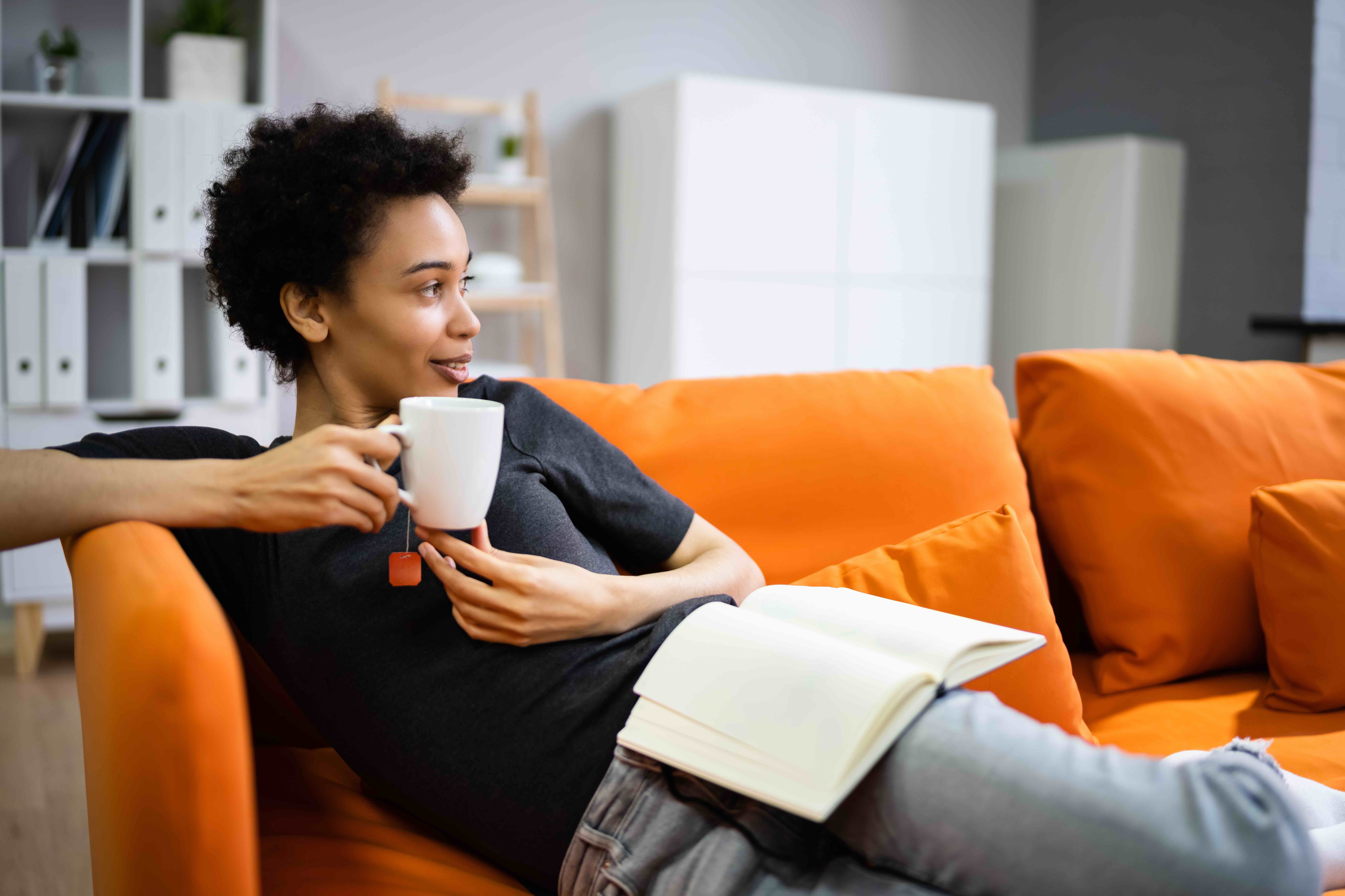 Woman sitting on couch drinking coffee waiting for laundry delivery.jpg