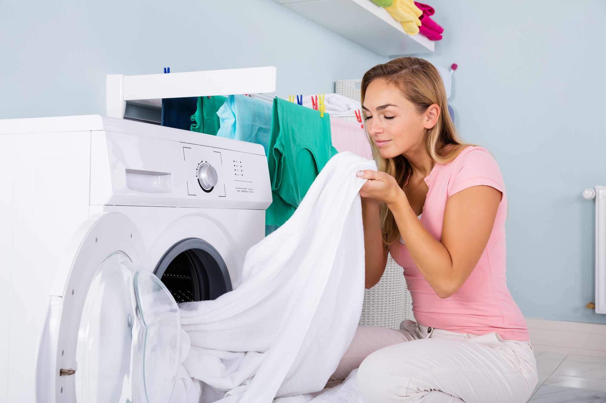 Woman smelling clean laundry sheets clothes.jpg