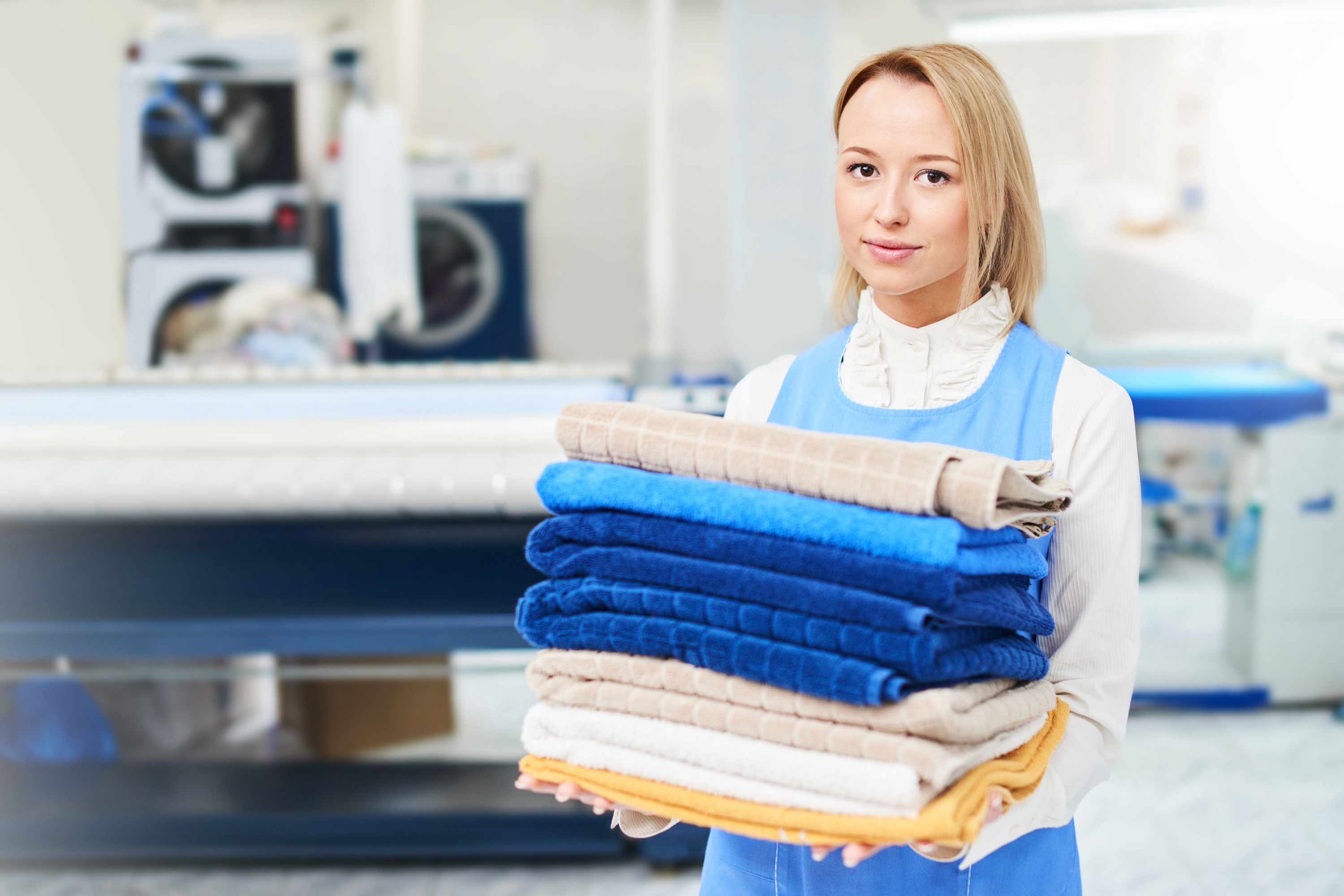 Young woman holding clean folded towels.jpg